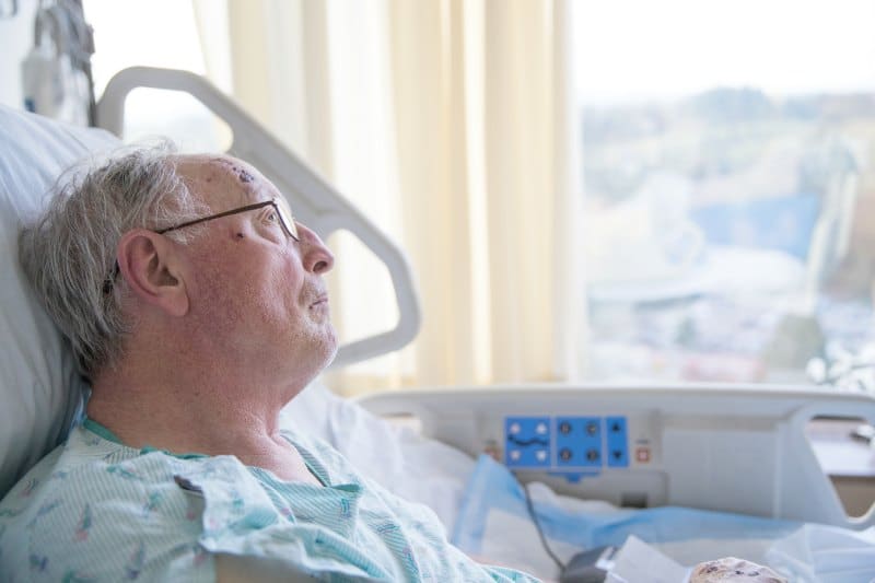 older man in hospital looking out window