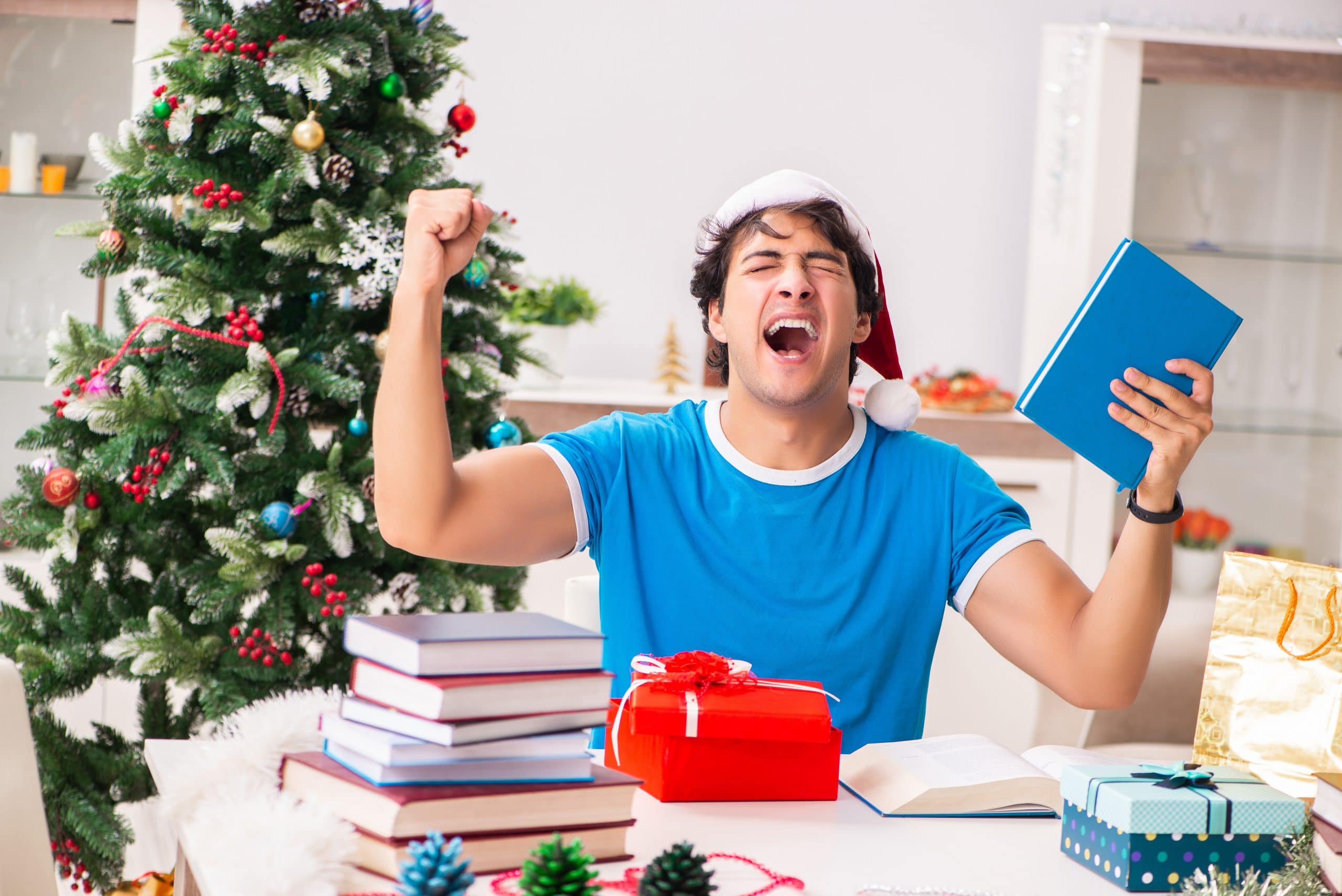 college student opening present in front of tree