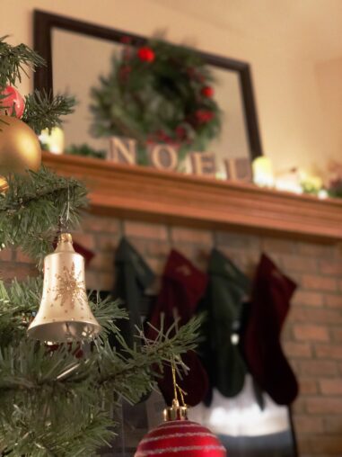 christmas ornament in front of fireplace with stockings