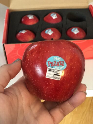 pazazz apple in front of box of apples