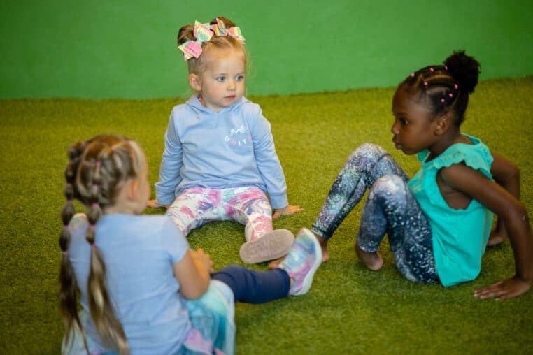 three children sitting on a floor