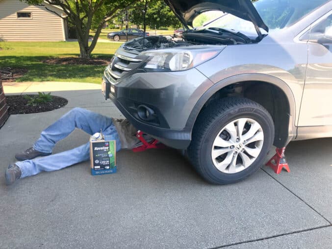 male under vehicle changing the oil