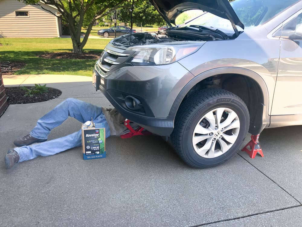 male under vehicle changing the oil