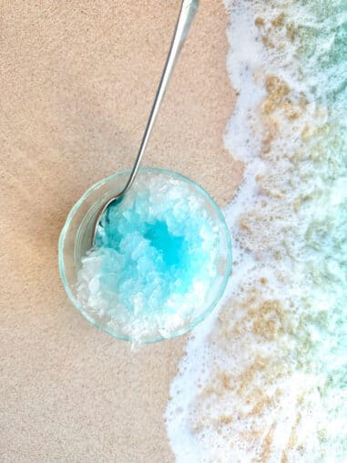bowl of blue hawaiian shaved ice on a beach