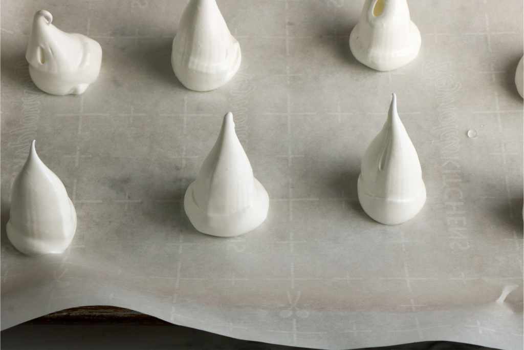 individual meringue peaks on a baking sheet