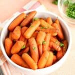 tender slow cooked baby carrots in a white bowl