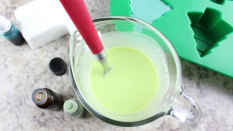 Lime green melted soap in a glass measuring cup