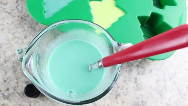 teal green mealted soap in a glass measuing cup