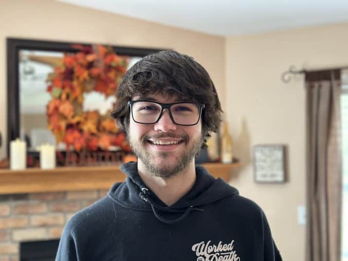 Young man indoors wearing black glasses